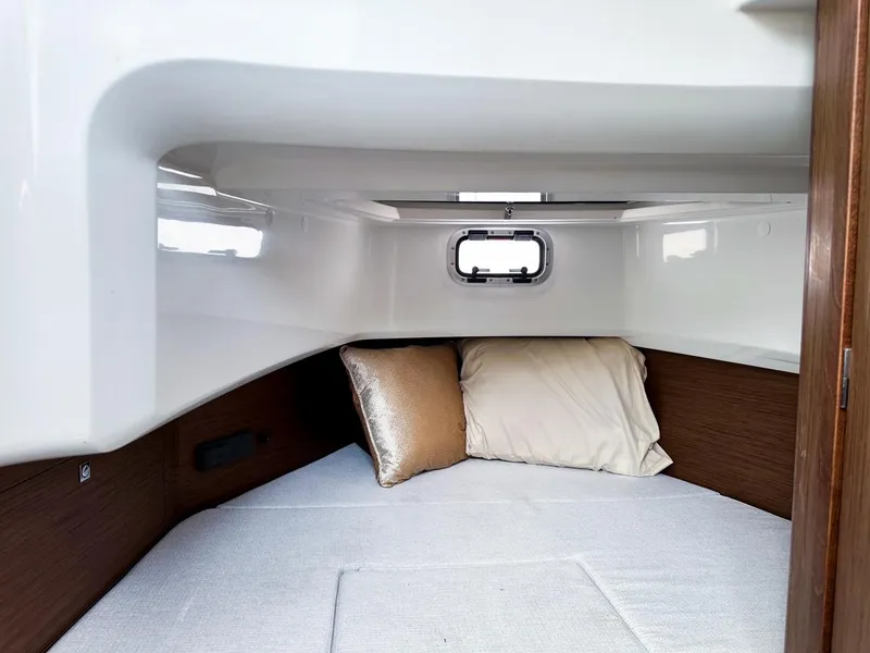 Slide: The Image of 2024 Jeanneau LEADER 9.0CC cabin interior with cozy bedding and porthole window. - 20