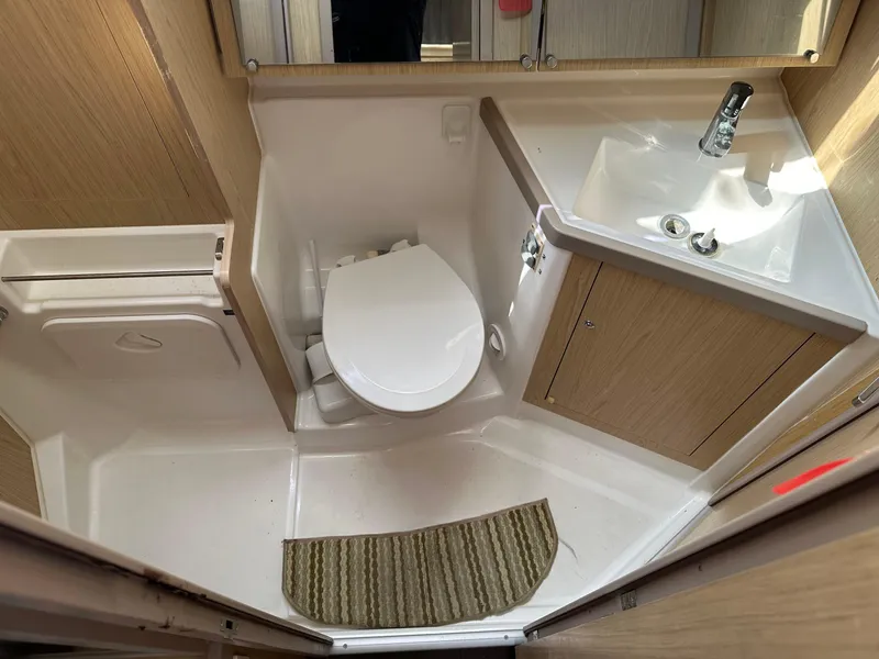 Slide: The Image of Beneteau Oceanis 41.1 2017 yacht bathroom with toilet, sink, and wooden cabinetry. - 14