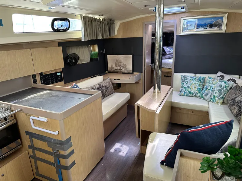 Slide: The Image of Interior of 2017 Beneteau Oceanis 41.1 yacht with modern kitchen and cozy seating area. - 2