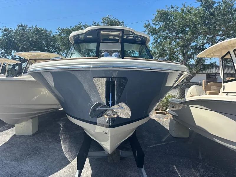 Slide: The Image of 2025 Chris-Craft Calypso 32 boat on trailer, parked outdoors under clear sky. - 2