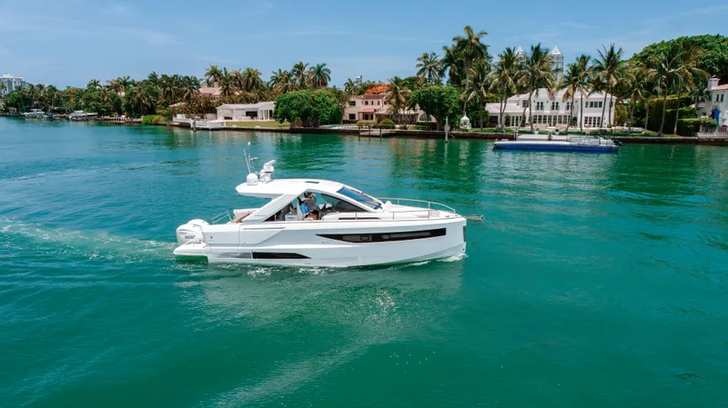 Slide: The Image of 2024 Jeanneau DB 37 OB cruising on a scenic, tropical waterway. - 2