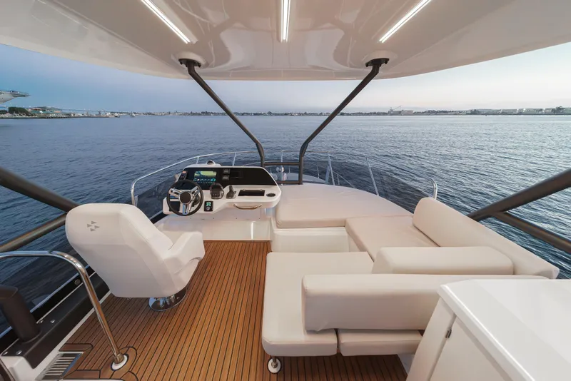 Slide: The Image of Luxurious 2025 Prestige F4.9 yacht interior with modern helm and seating, overlooking serene ocean. - 15