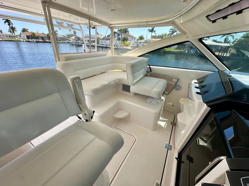 Slide: The Image of 2018 Tiara Yachts 4300 Open interior with white seating and waterfront view. - 21