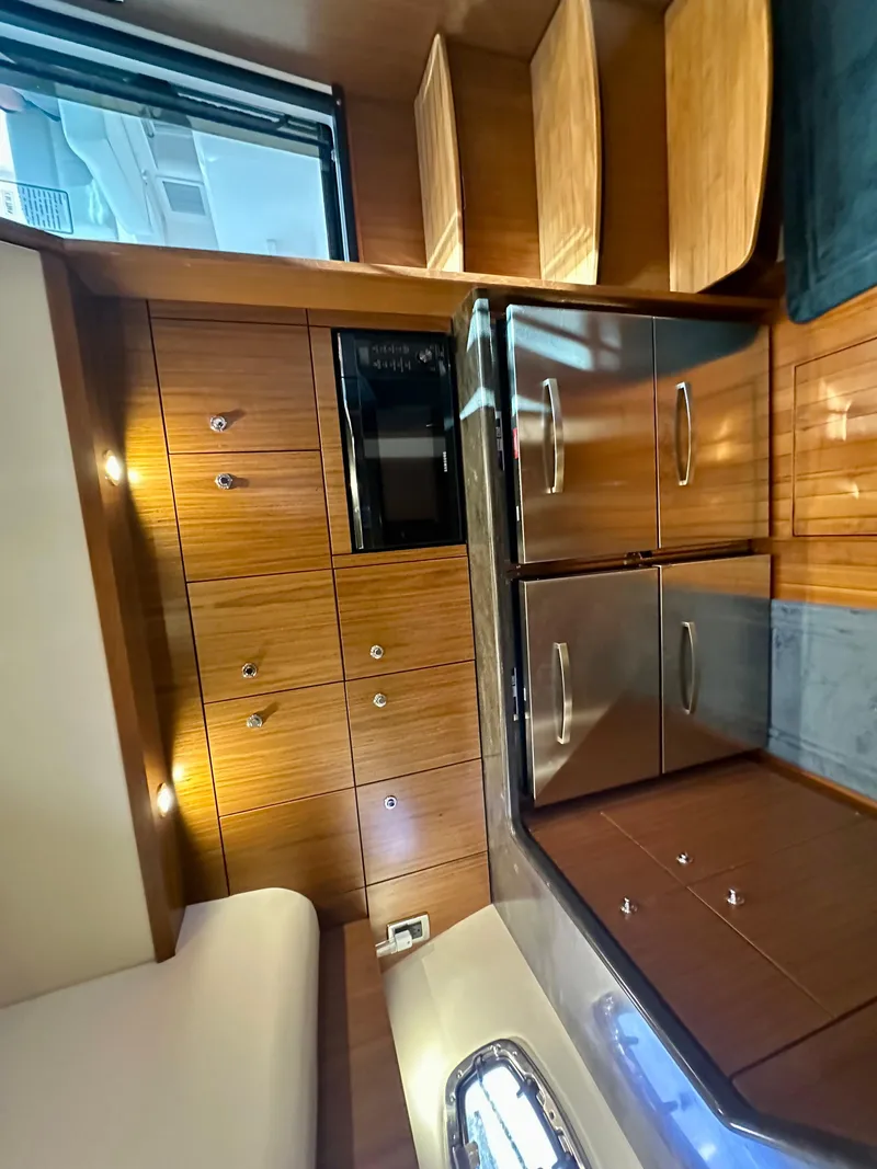 Slide: The Image of Interior of 2018 Tiara Yachts 4300 Open with wood cabinetry and stainless steel appliances. - 25