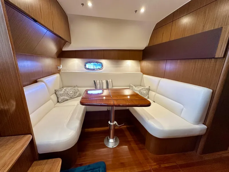Slide: The Image of 2018 Tiara Yachts 4300 Open interior with white seating and wooden table. - 27