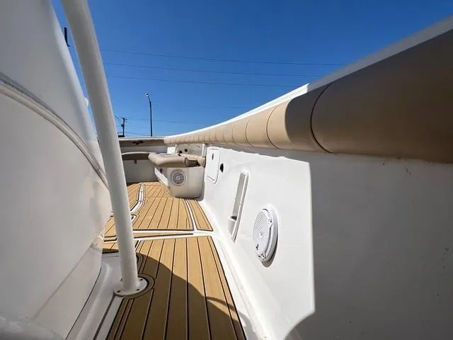 Slide: The Image of 2016 Glasstream 360 SCX boat deck with wood finish and white accents under clear blue sky. - 15