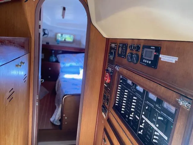 Slide: The Image of Interior view of 1999 Hunter Passage 420 sailboat, featuring control panels and cozy cabin. - 10