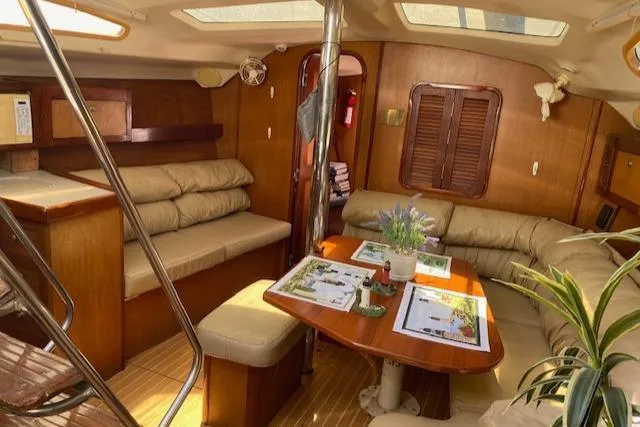 Slide: The Image of Interior of 1999 Hunter Passage 420 sailboat with cozy seating and dining area. - 15