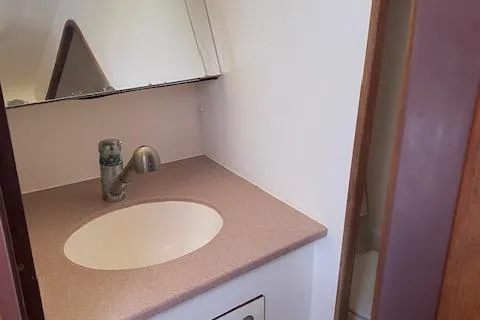 Slide: The Image of Bathroom sink area in 1999 Hunter Passage 420 yacht, featuring a modern faucet and mirror. - 18
