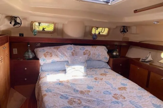 Slide: The Image of Cozy cabin interior of 1999 Hunter Passage 420 sailboat with floral bedding and wooden accents. - 19