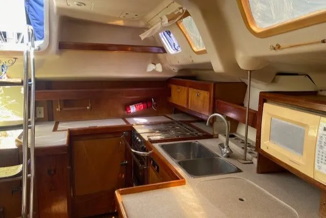 Slide: The Image of Interior of 1999 Hunter Passage 420 sailboat kitchen with wood cabinetry and appliances. - 5