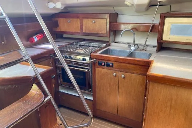 Slide: The Image of Interior of 1999 Hunter Passage 420 yacht kitchen with wooden cabinets and stainless steel sink. - 6