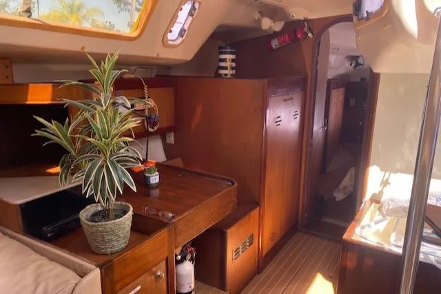Slide: The Image of Interior of 1999 Hunter Passage 420 sailboat with wooden cabinetry and potted plant. - 8