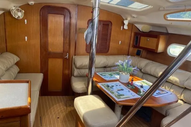 Slide: The Image of Interior of 1999 Hunter Passage 420 sailboat with cozy seating and dining area. - 9