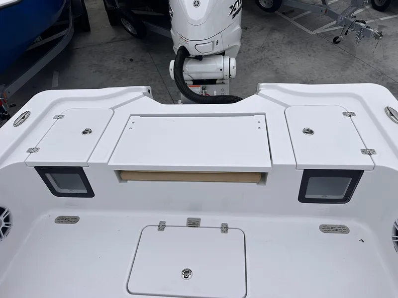 Slide: The Image of 2024 Sportsman Masters 267OE Bay Boat deck with storage compartments and motor. - 19