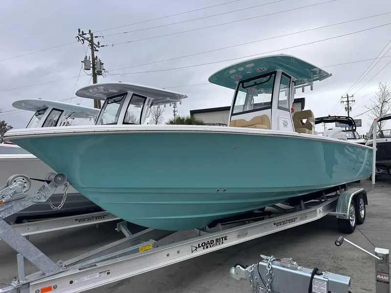 Slide: The Image of 2024 Sportsman Masters 267OE Bay Boat on trailer, teal color, side view. - 2