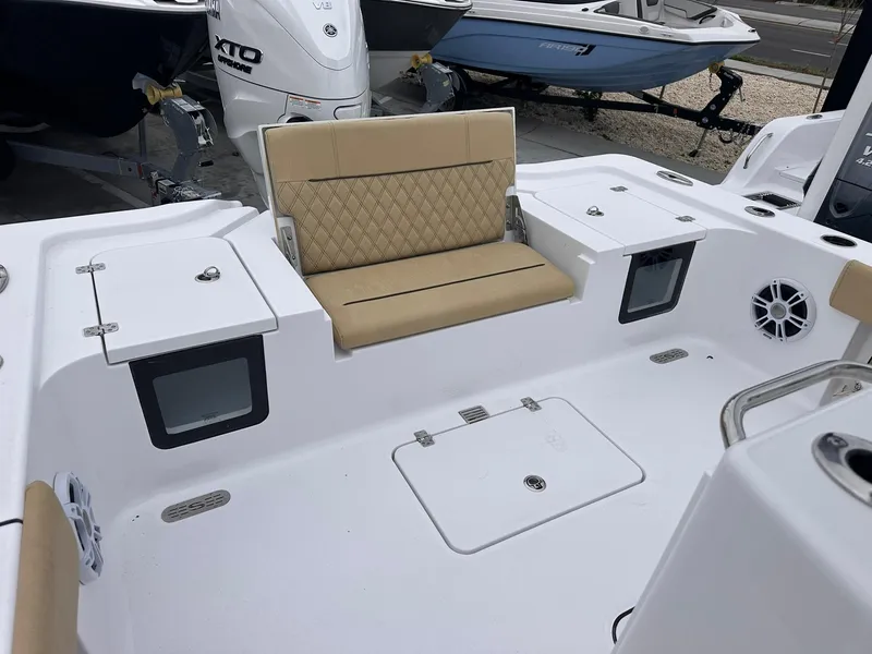Slide: The Image of 2024 Sportsman Masters 267OE Bay Boat interior with tan seating and storage compartments. - 21