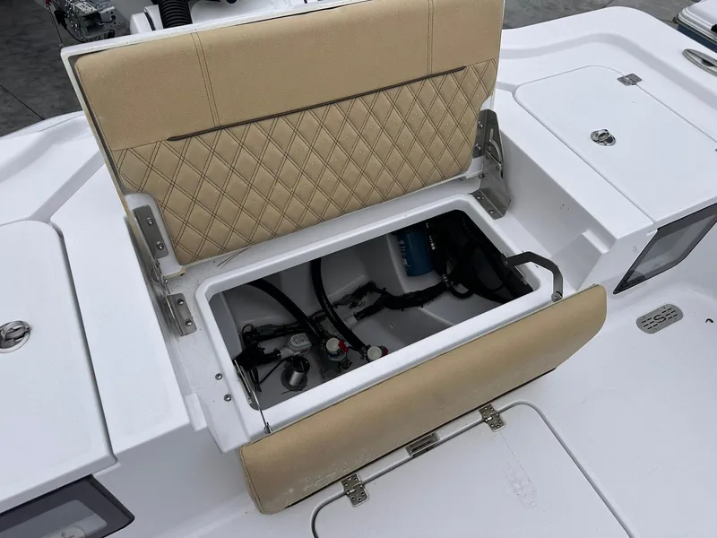 Slide: The Image of 2024 Sportsman Masters 267OE Bay Boat storage compartment with cushioned seat and diamond stitching. - 23