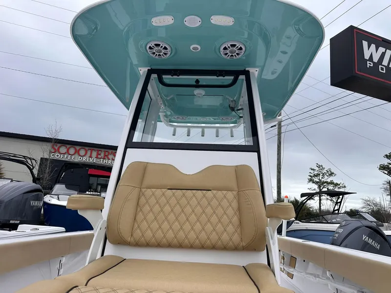 Slide: The Image of 2024 Sportsman Masters 267OE Bay Boat with tan seating and teal canopy, displayed outdoors. - 37