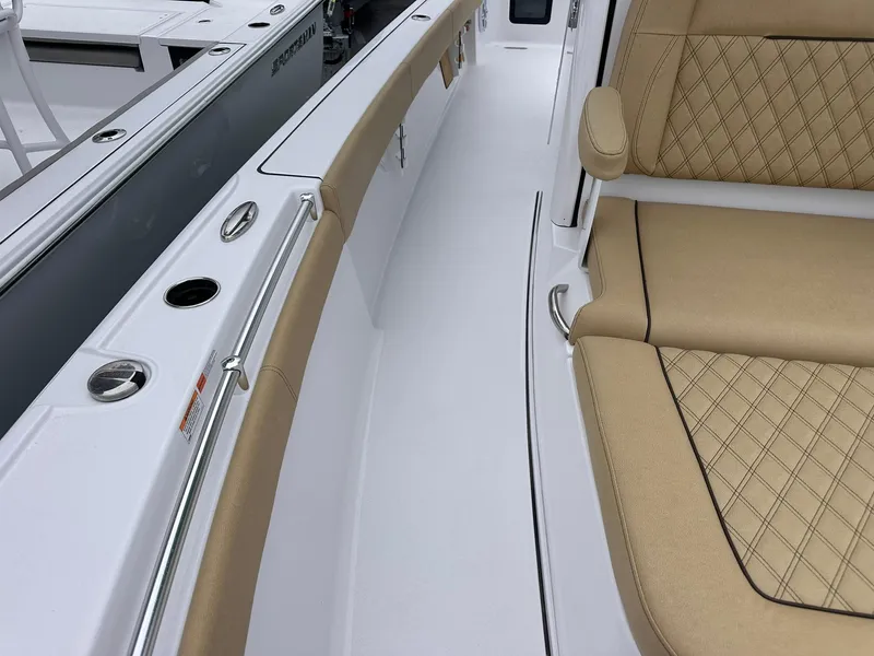 Slide: The Image of 2024 Sportsman Masters 267OE Bay Boat interior with tan seating and sleek white deck. - 40