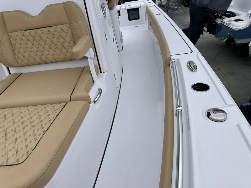 Slide: The Image of 2024 Sportsman Masters 267OE Bay Boat interior with tan seating and sleek white deck. - 41