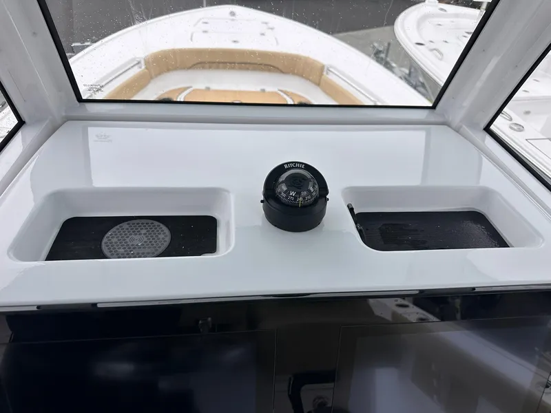 Slide: The Image of 2024 Sportsman Masters 267OE Bay Boat dashboard with compass and storage compartments. - 43