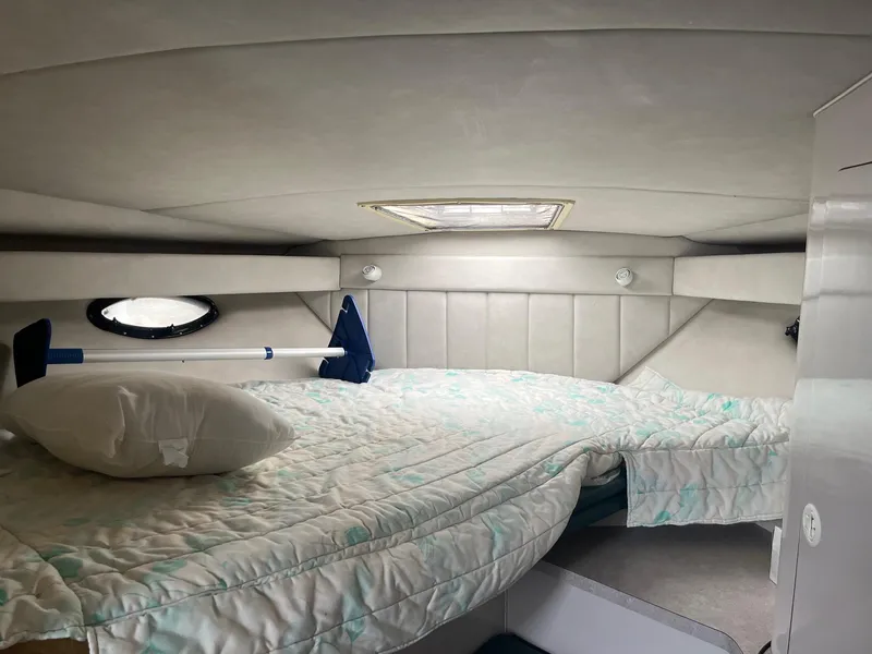 Slide: The Image of 1993 Regal 9.8 VENTURA boat cabin interior with bed and porthole. - 12