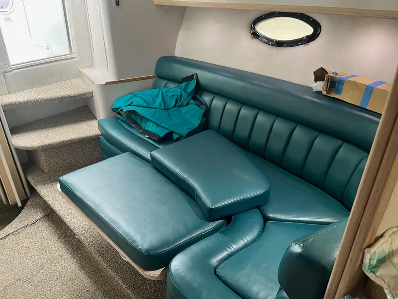 Slide: The Image of 1993 Regal 9.8 VENTURA boat interior with teal seating and small window. - 13