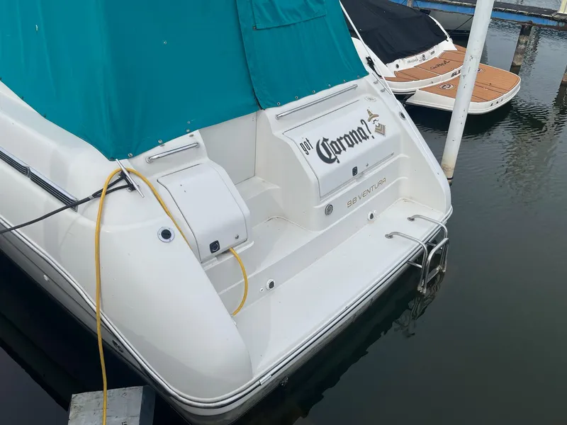 Slide: The Image of 1993 Regal 9.8 VENTURA boat docked with teal cover and visible branding. - 2