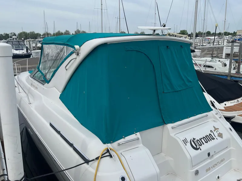 Slide: The Image of 1993 Regal 9.8 VENTURA boat with teal canopy docked at marina. - 3