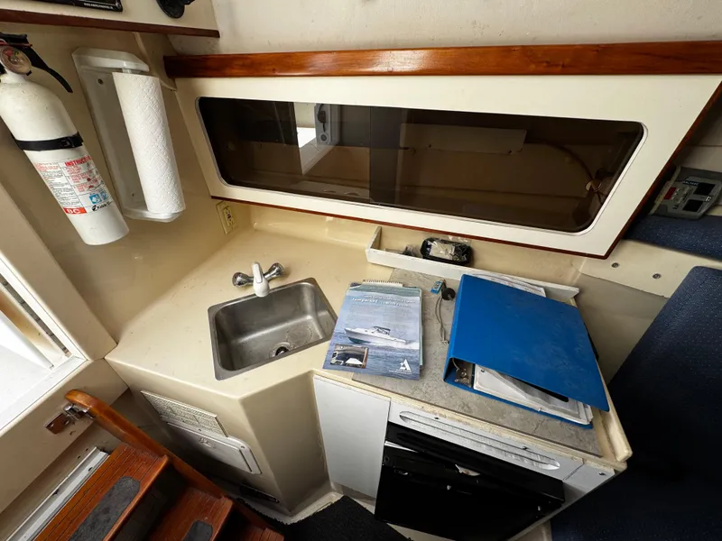 Slide: The Image of 2005 Albin 26 Tournament Express cabin with sink, countertop, and storage. - 10