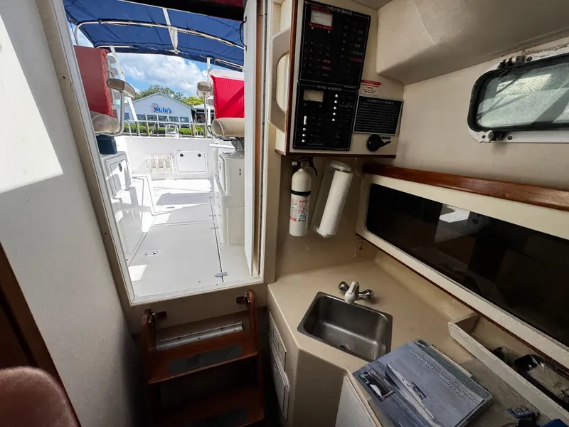 Slide: The Image of Interior of 2005 Albin 26 Tournament Express boat, featuring kitchenette and control panel. - 12