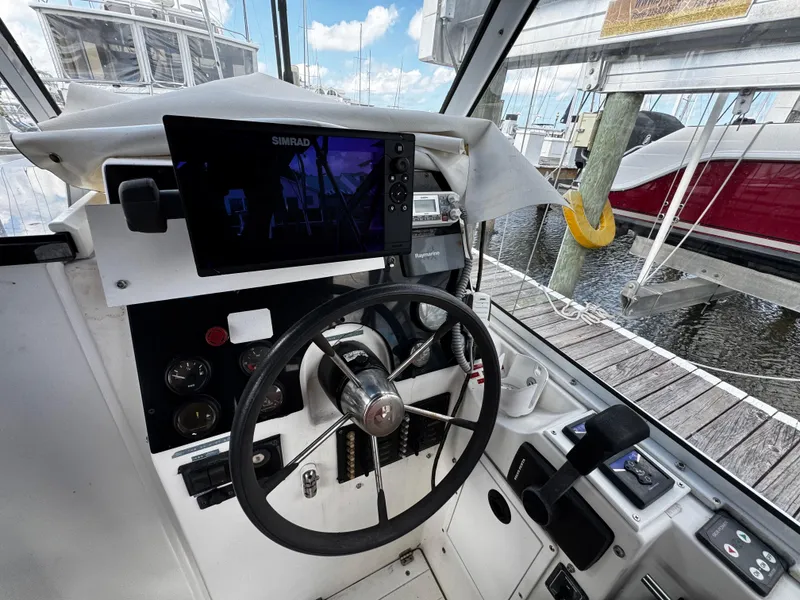 Slide: The Image of 2005 Albin 26 Tournament Express helm with steering wheel and navigation system at marina. - 3