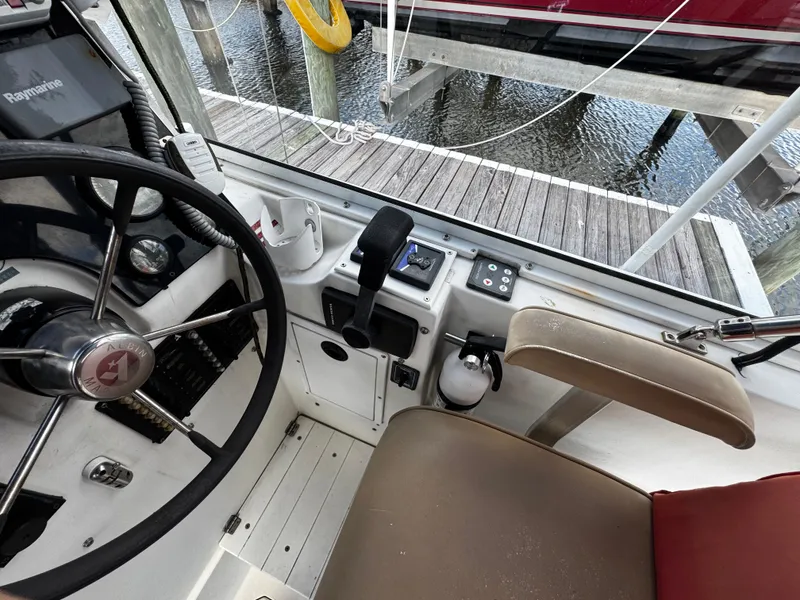 Slide: The Image of 2005 Albin 26 Tournament Express helm with steering wheel and controls, dockside view. - 5