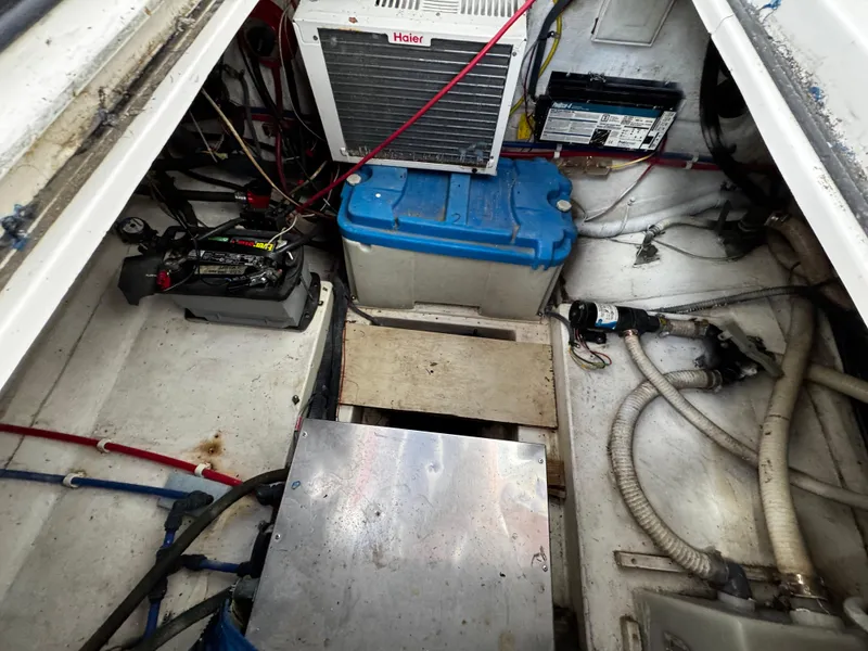 Slide: The Image of Engine compartment of a 2005 Albin 26 Tournament Express boat with visible equipment and wiring. - 6