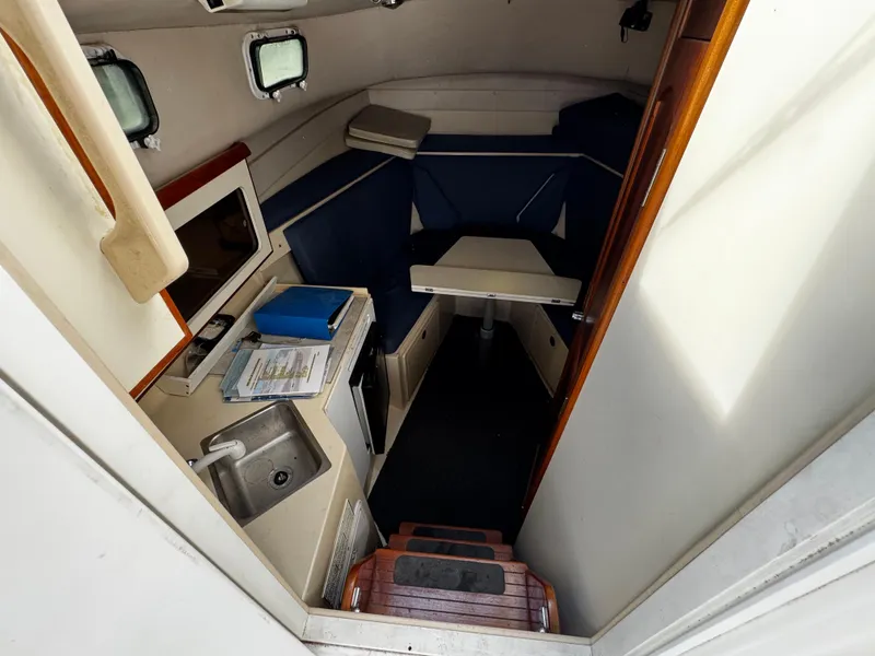 Slide: The Image of 2005 Albin 26 Tournament Express cabin interior with kitchenette and seating area. - 8