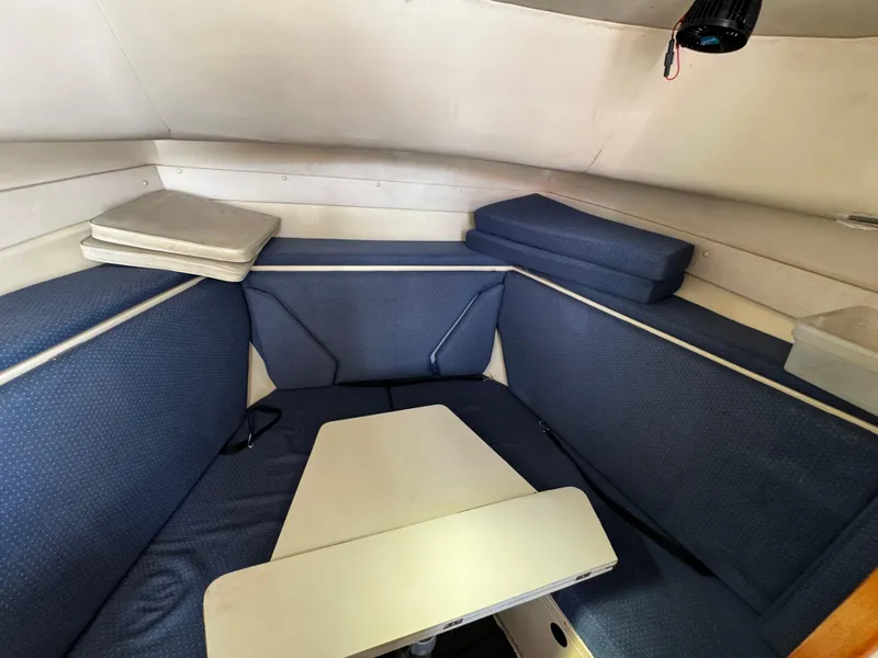 Slide: The Image of 2005 Albin 26 Tournament Express cabin with blue seating and white table. - 9