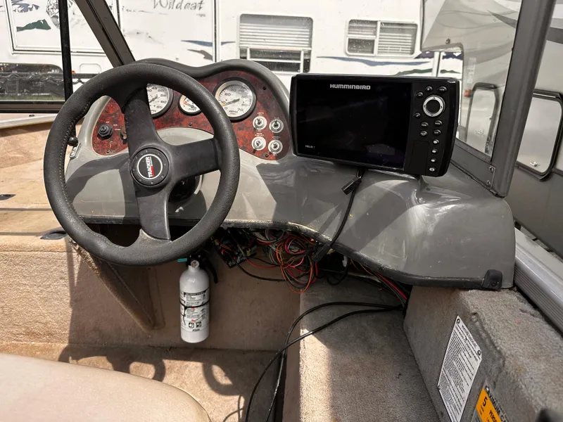 Slide: The Image of 2006 Tracker Pro Guide V-17 WT boat dashboard with steering wheel and Humminbird fish finder. - 8
