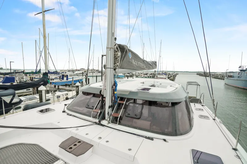 Slide: The Image of 2022 Nautitech 40 Open catamaran docked at a marina under a clear blue sky. - 3