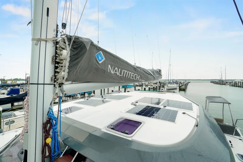 Slide: The Image of 2022 Nautitech 40 Open catamaran docked, featuring solar panels and sail cover. - 49