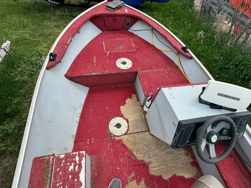 Slide: The Image of 1994 Alumacraft SC boat interior with red carpet and steering console. - 5