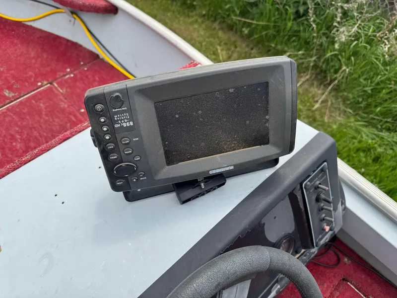 Slide: The Image of Fishfinder on 1994 Alumacraft SC boat dashboard with red carpet and steering wheel. - 8