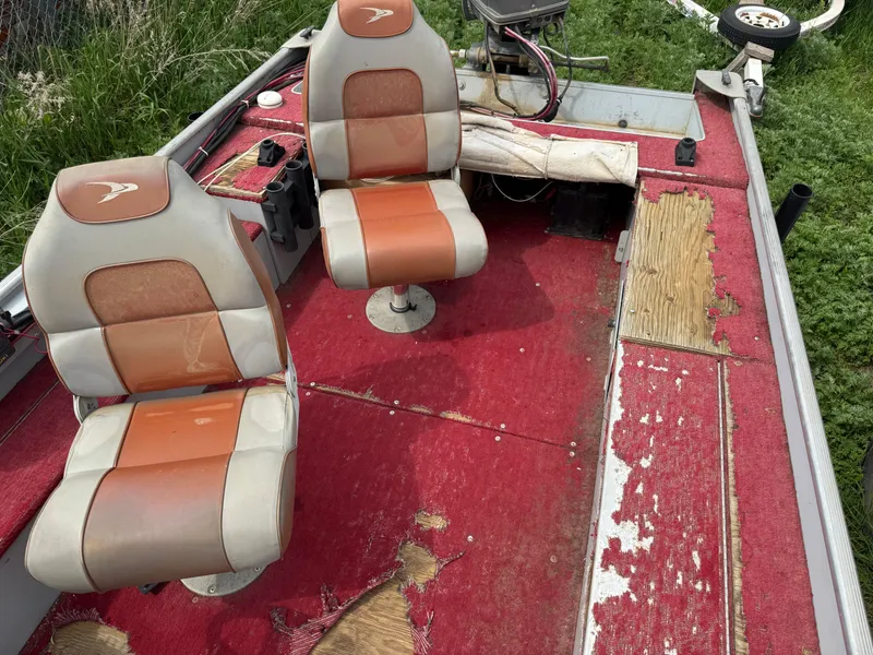 Slide: The Image of 1994 Alumacraft SC boat interior with worn red carpet and two seats. - 9