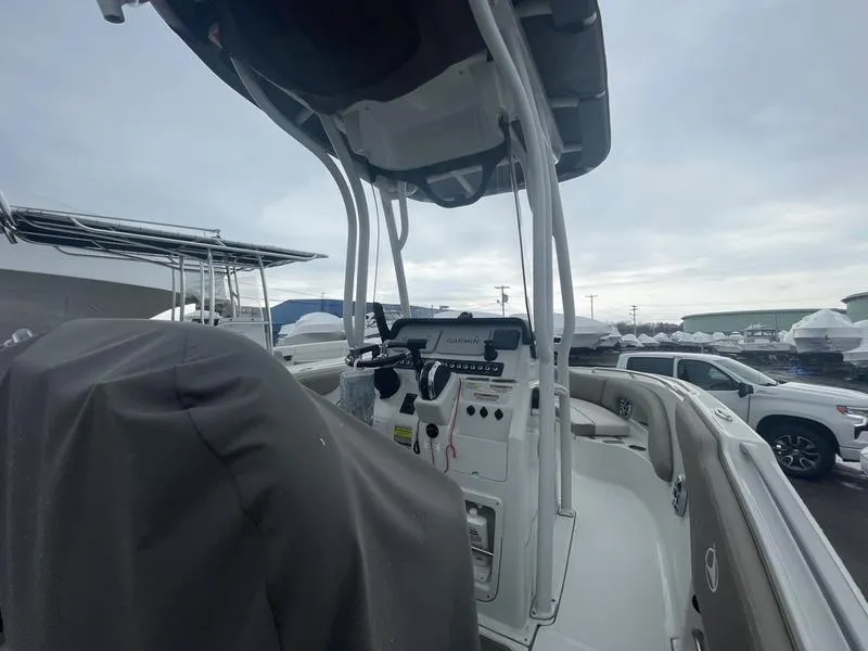 Slide: The Image of 2023 Finseeker 210 FS.2 boat with covered seating and control panel, docked under cloudy skies. - 8