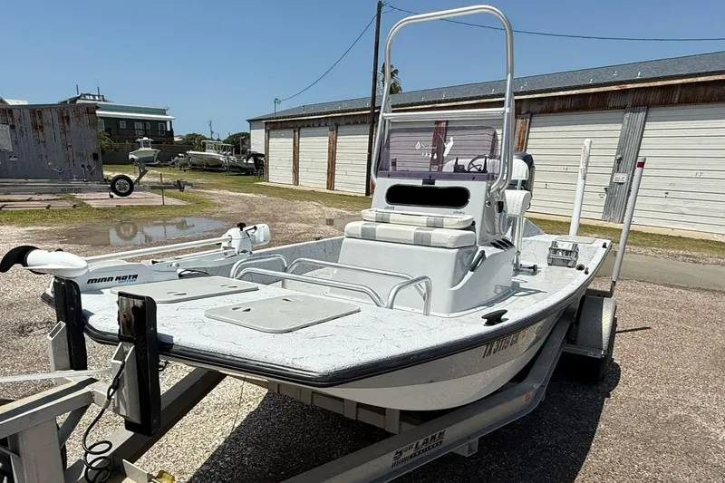 Slide: The Image of 2014 Majek 18 Redfish boat on trailer, parked outdoors near storage units. - 4