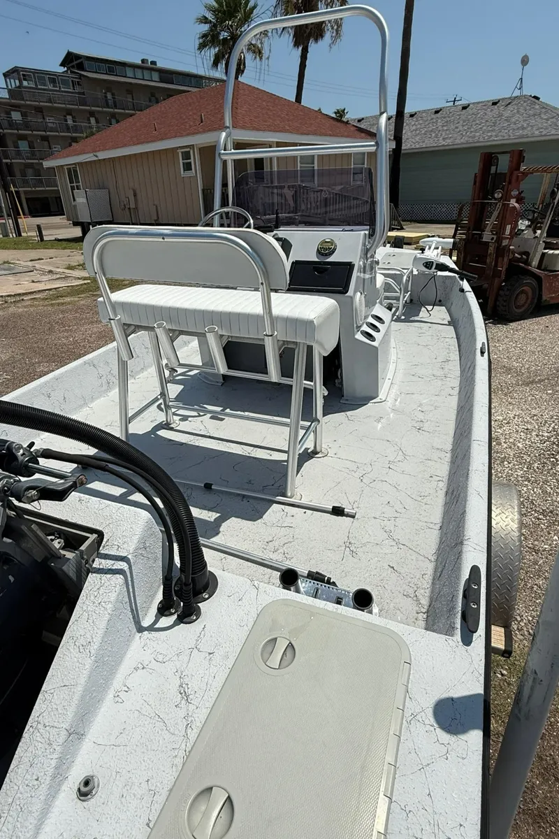 Slide: The Image of 2014 Majek 18 Redfish boat with center console and seating, parked outdoors. - 8