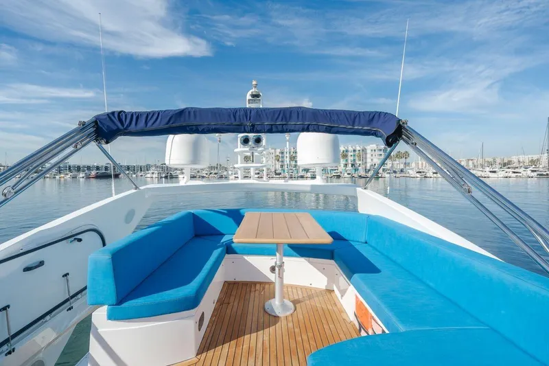 Slide: The Image of 2010 Sunseeker Manhattan 60 yacht with blue seating and wooden table on deck. - 11
