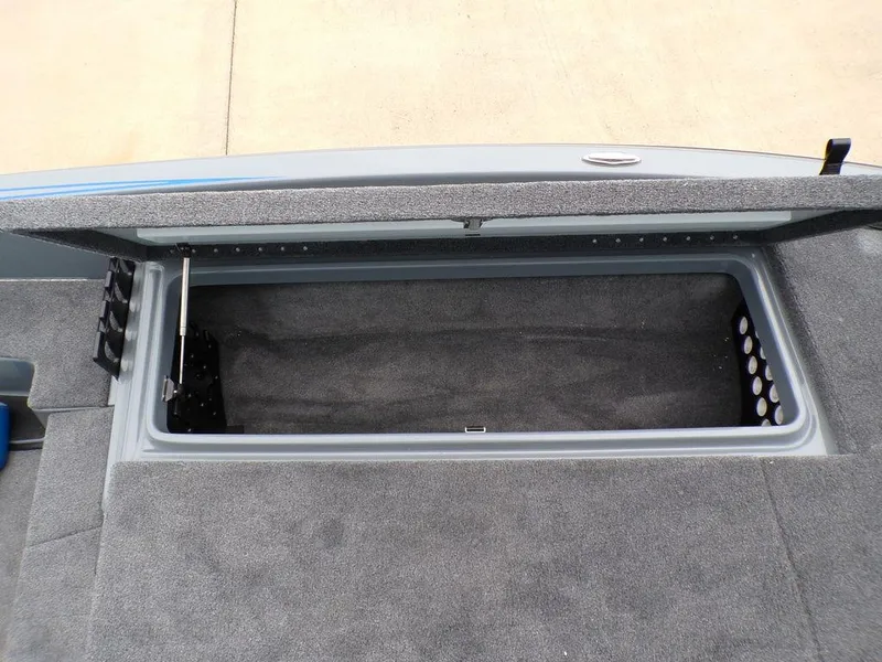 Slide: The Image of Open storage compartment in a 2025 Phoenix 921 ELITE boat, featuring carpeted interior. - 10