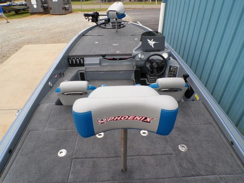 Slide: The Image of 2025 Phoenix 921 ELITE boat interior with gray and blue seating, steering console, and spacious deck. - 12