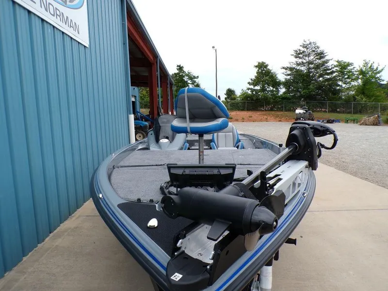 Slide: The Image of 2025 Phoenix 921 ELITE fishing boat with advanced equipment, parked near a blue building. - 22